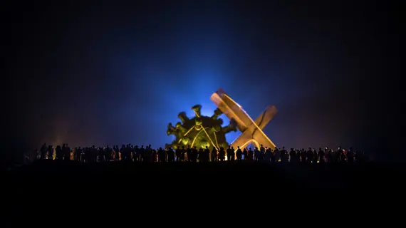 Coronavirus 2019-nCov novel coronavirus concept. Crowd looking on big Corona virus model at night with fog and backlight. Creative artwork decoration. Selective focus.