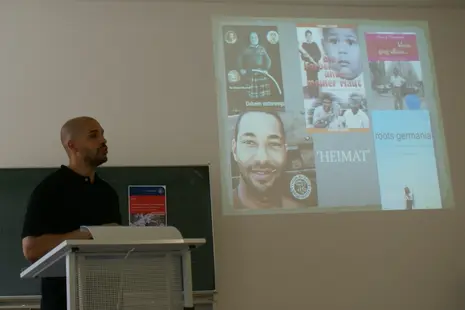 Cedric Essi delivering his guest lecture "The Allure of Diasporic Homecoming: Barack Obama's Dreams from My Father and Ika Hgel-Marshall's Daheim Unterwegs".